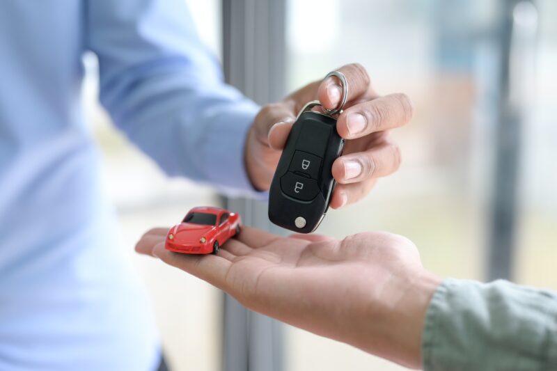 Close-up shot of Sellers handing over car keys to customers,Car sales ideas.